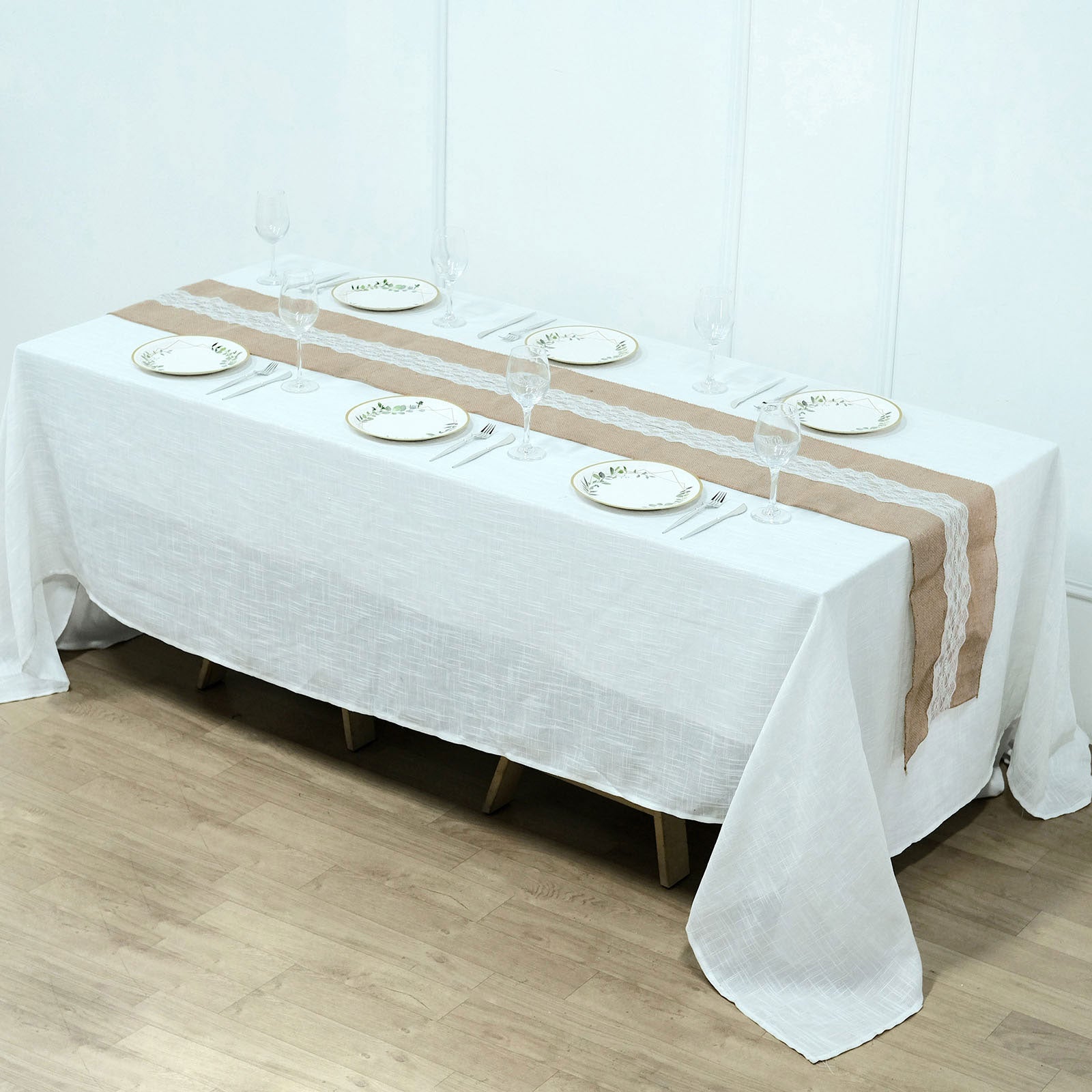 Natural jute burlap table runner with white lace on a white table setting.