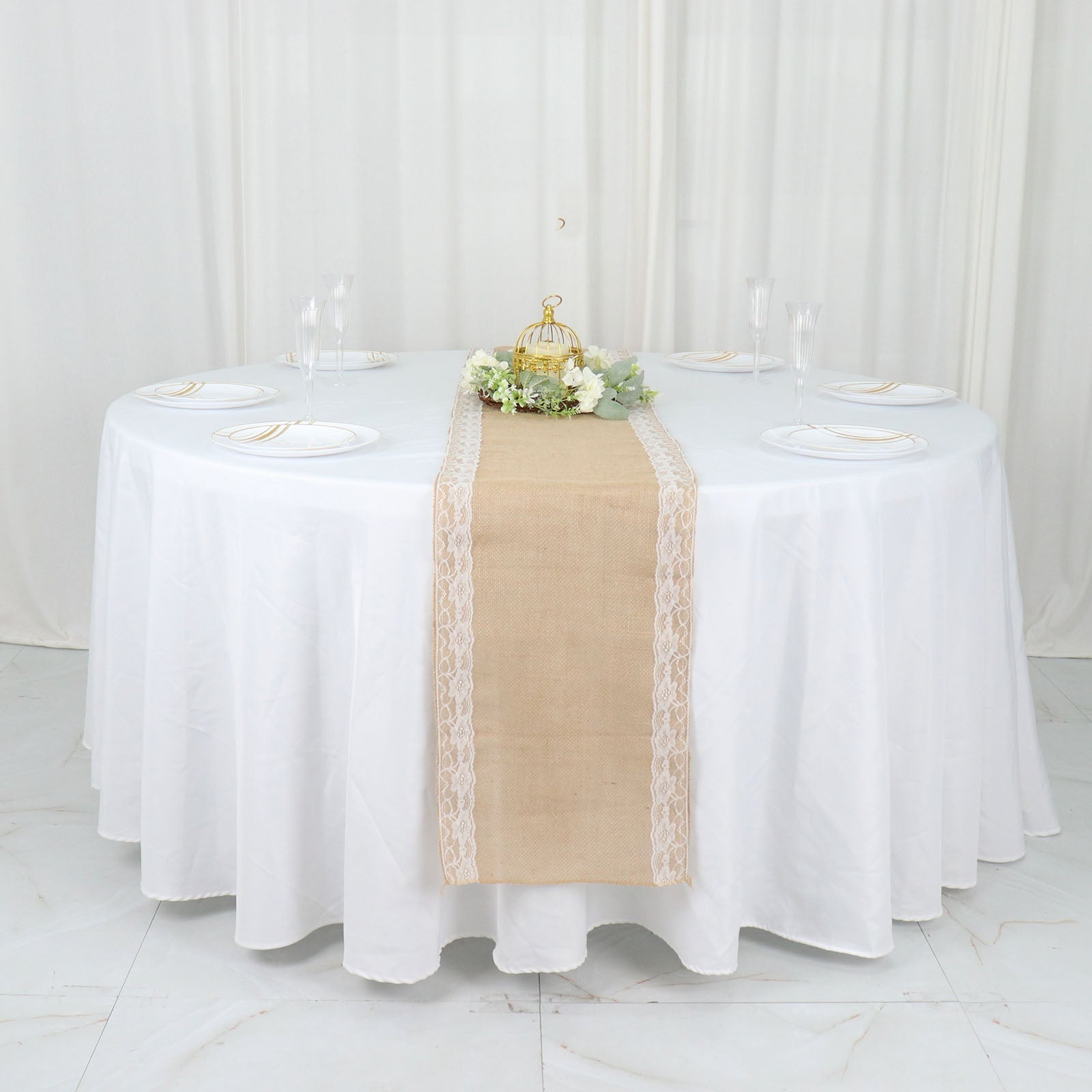 Natural jute burlap table runner with white lace trim on a round table.