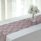 Violet amethyst floral lace table runner on a white table with a vase of roses.