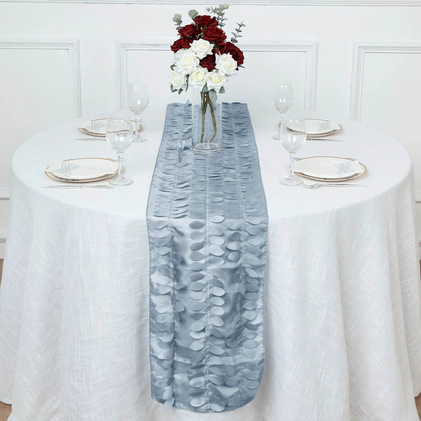 Dusty blue 3D leaf petal taffeta fabric table runner on a white table.