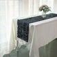 Black 3D leaf petal taffeta fabric table runner on a white table.