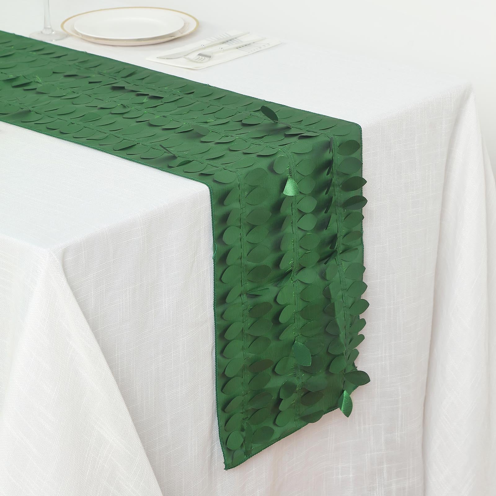 Green 3D leaf petal taffeta fabric table runner on a white table.