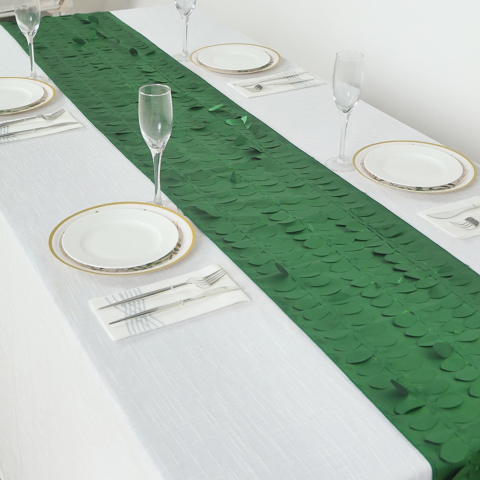 Green 3D leaf petal taffeta fabric table runner on a white table.