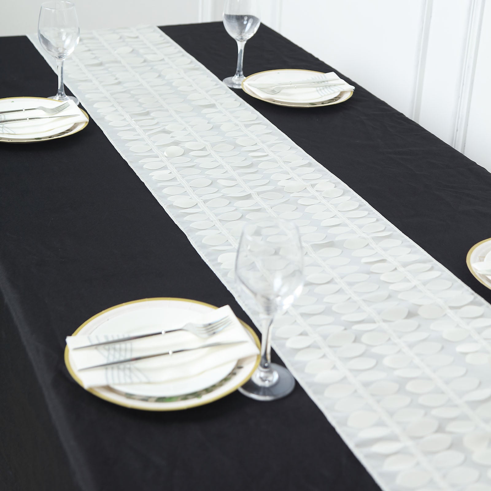 Ivory 3D leaf petal taffeta fabric table runner on a black table.