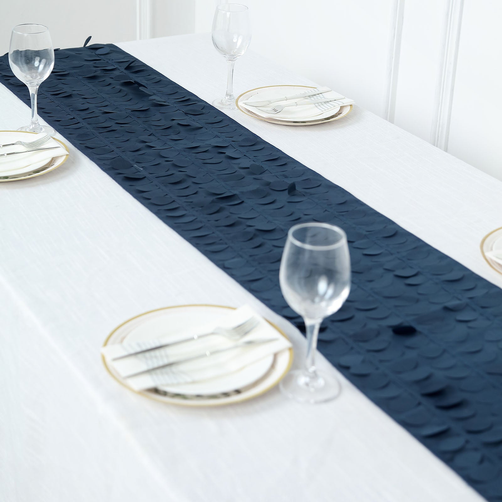 Navy blue 3D leaf petal taffeta fabric table runner on a white table.