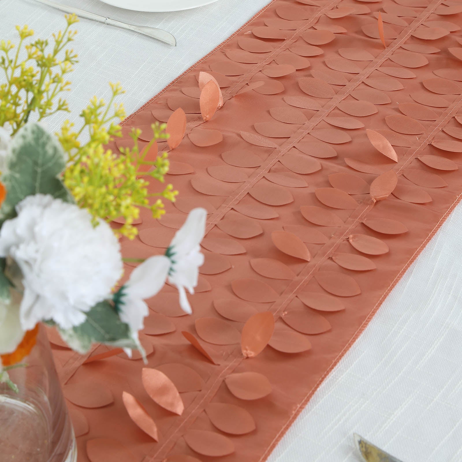 Terracotta 3D leaf petal taffeta fabric table runner on a dining table.