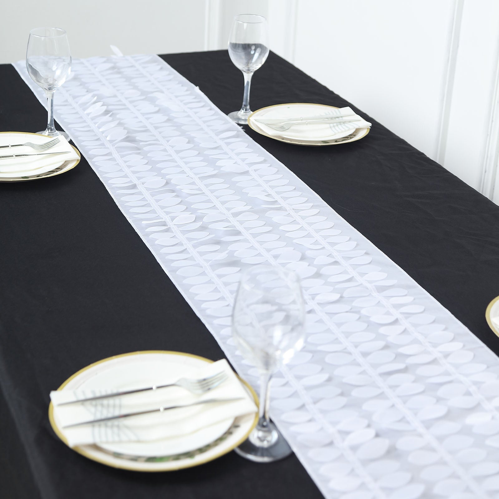 White 3D leaf petal taffeta fabric table runner on a black table.