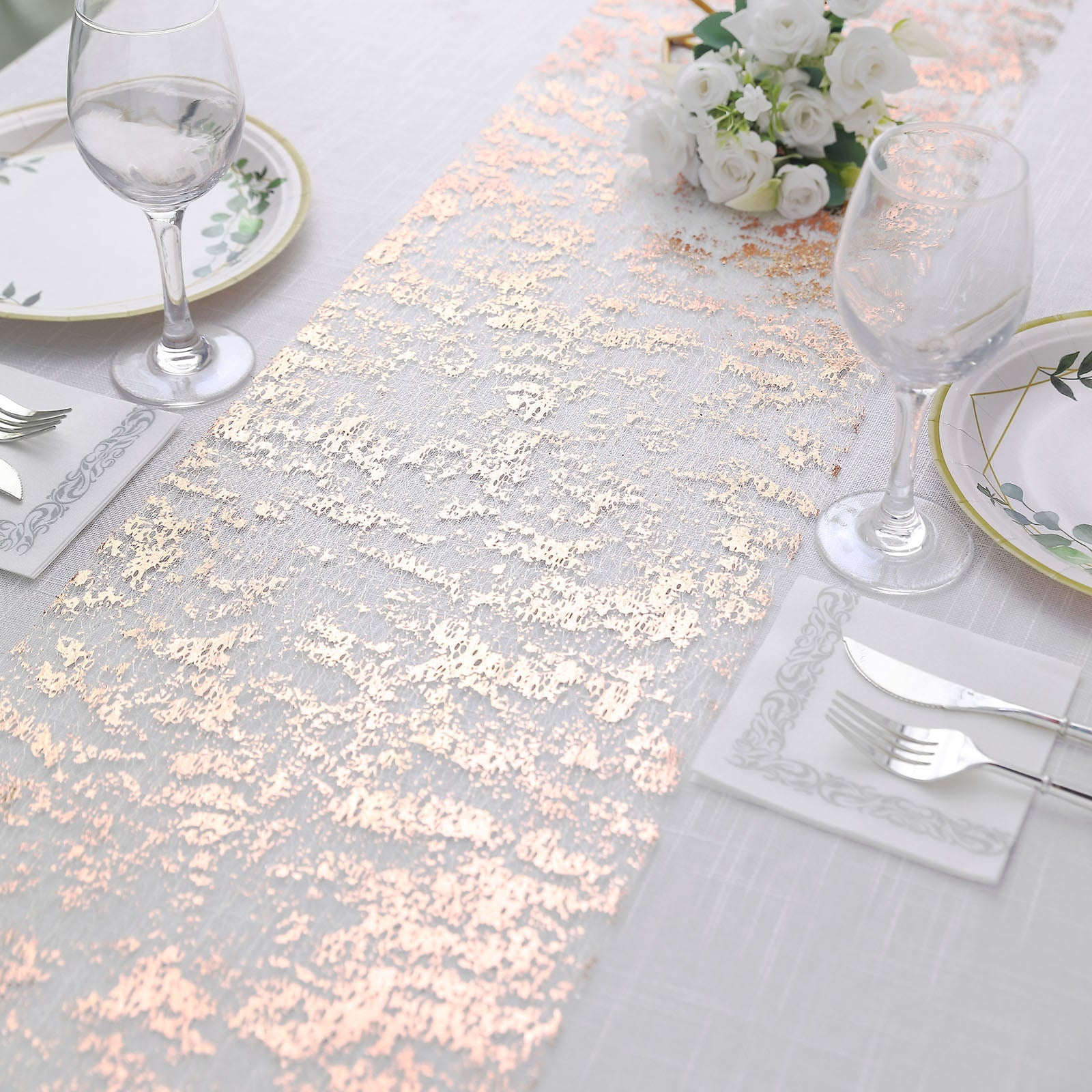 Metallic rose gold foil thin mesh table runner on a dining table.