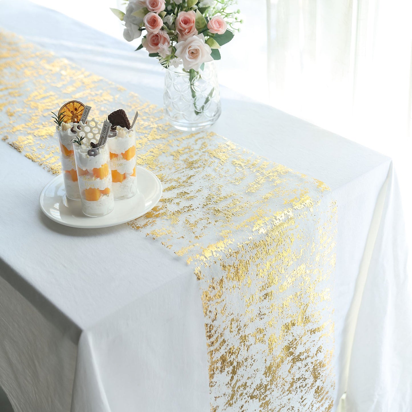 Sparkly metallic gold foil disposable table runner on a white table.