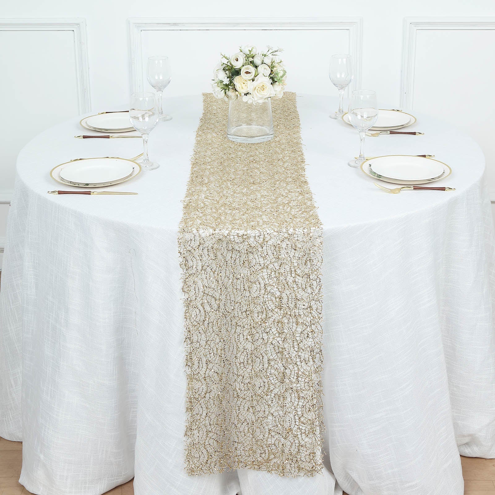 Gold sequin mesh lace table runner on a white table setting for wedding decor.