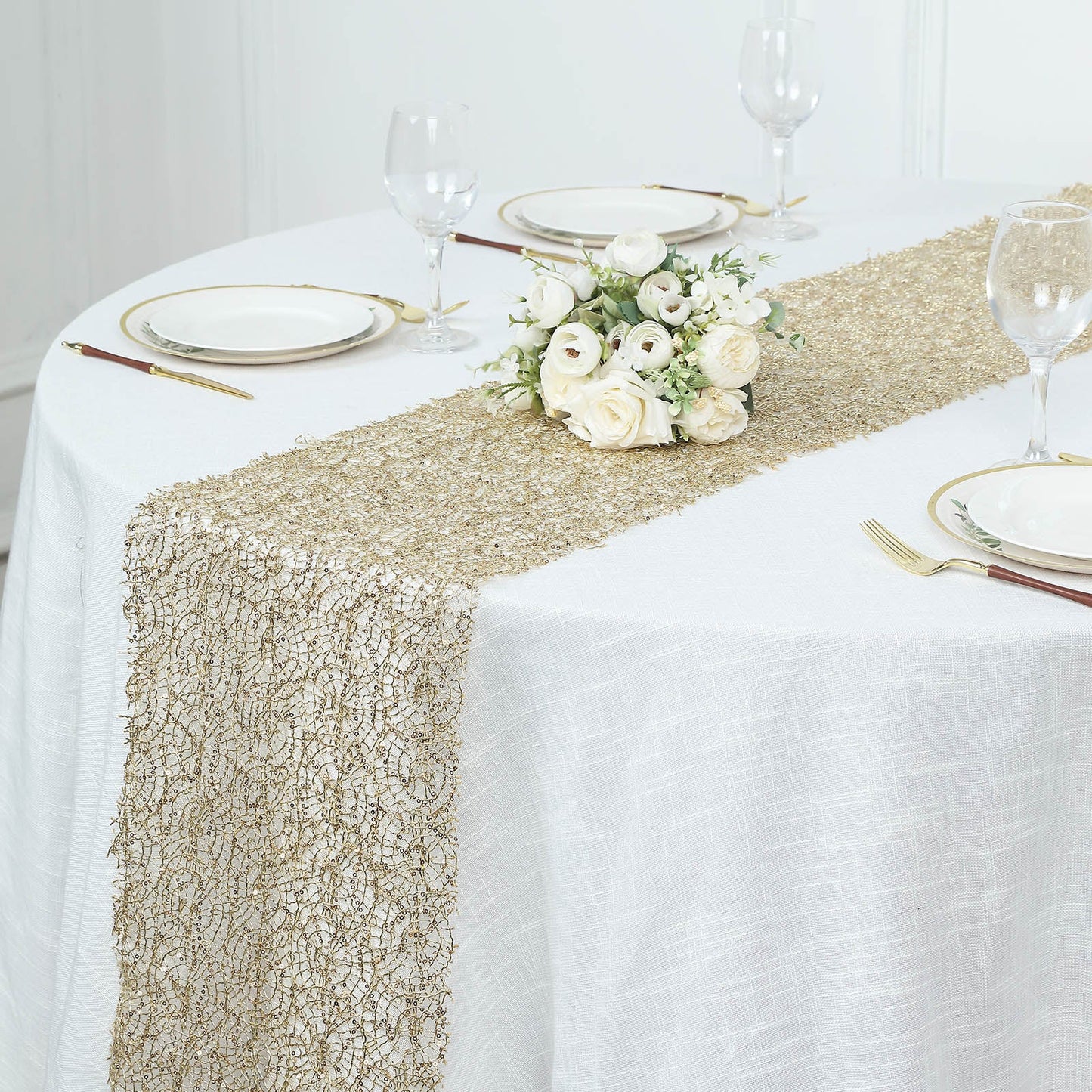 Gold sequin lace table runner on a white table setting.