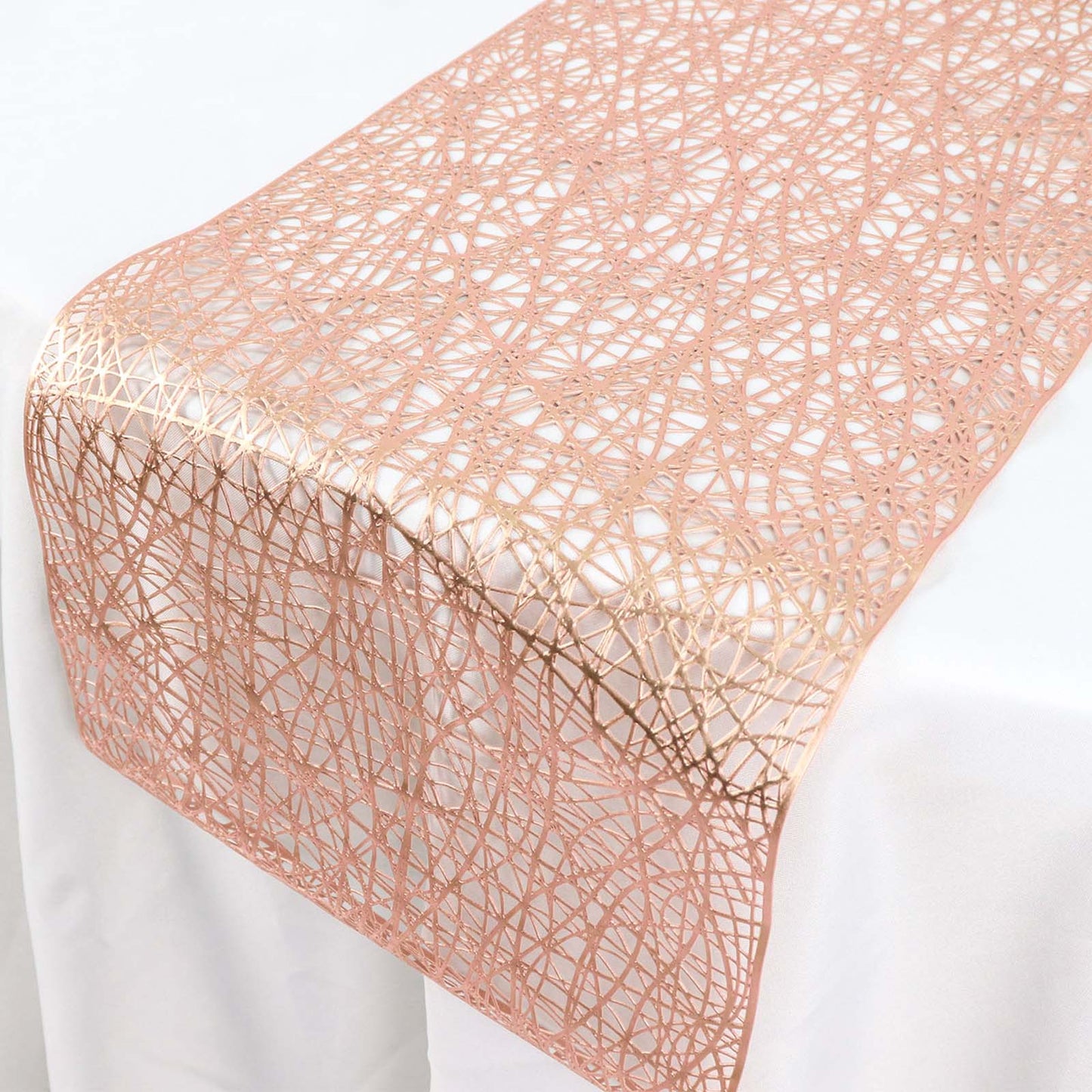 Metallic rose gold non-slip plastic woven vinyl table runner on a white table.