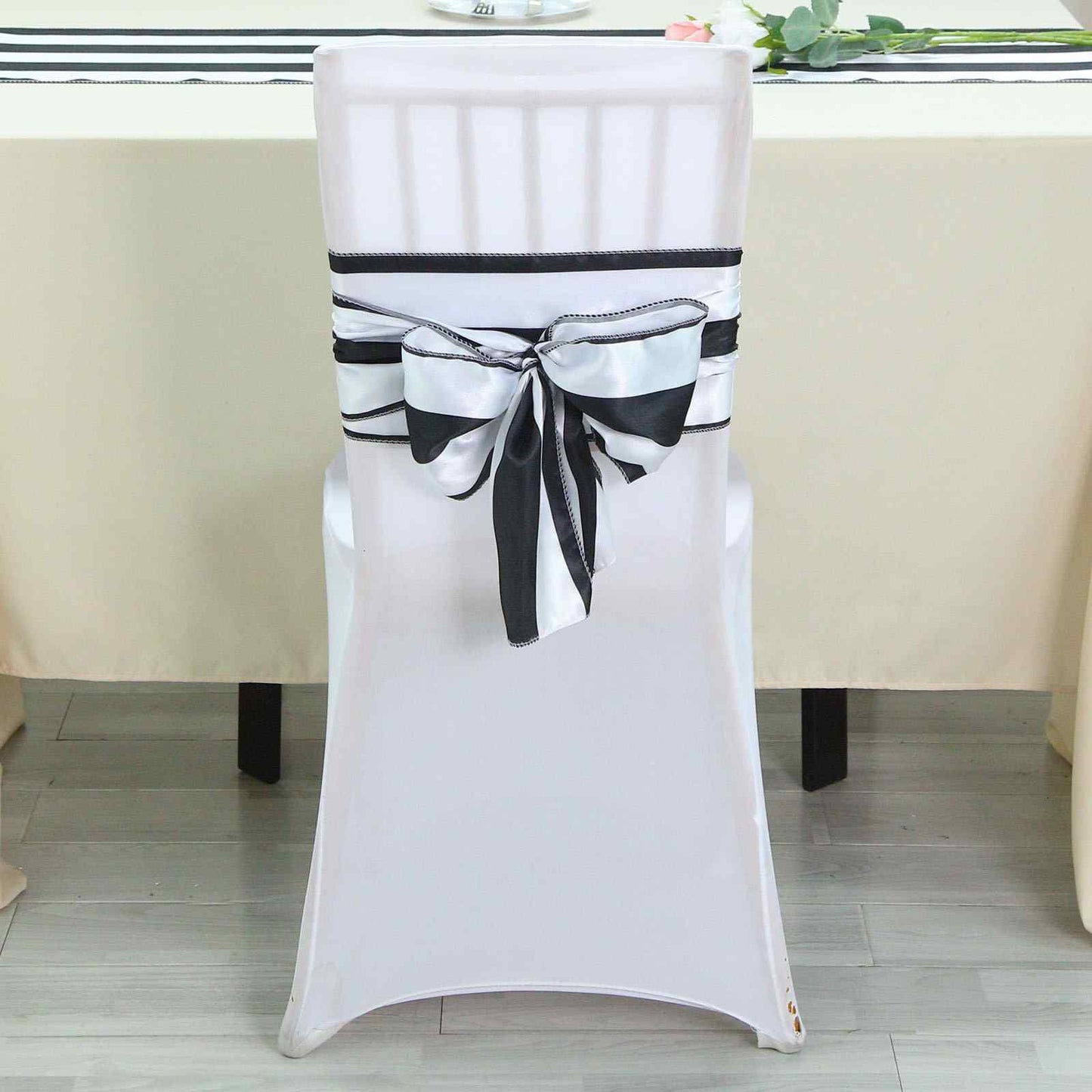 Black and white striped satin chair sash on a white chair.