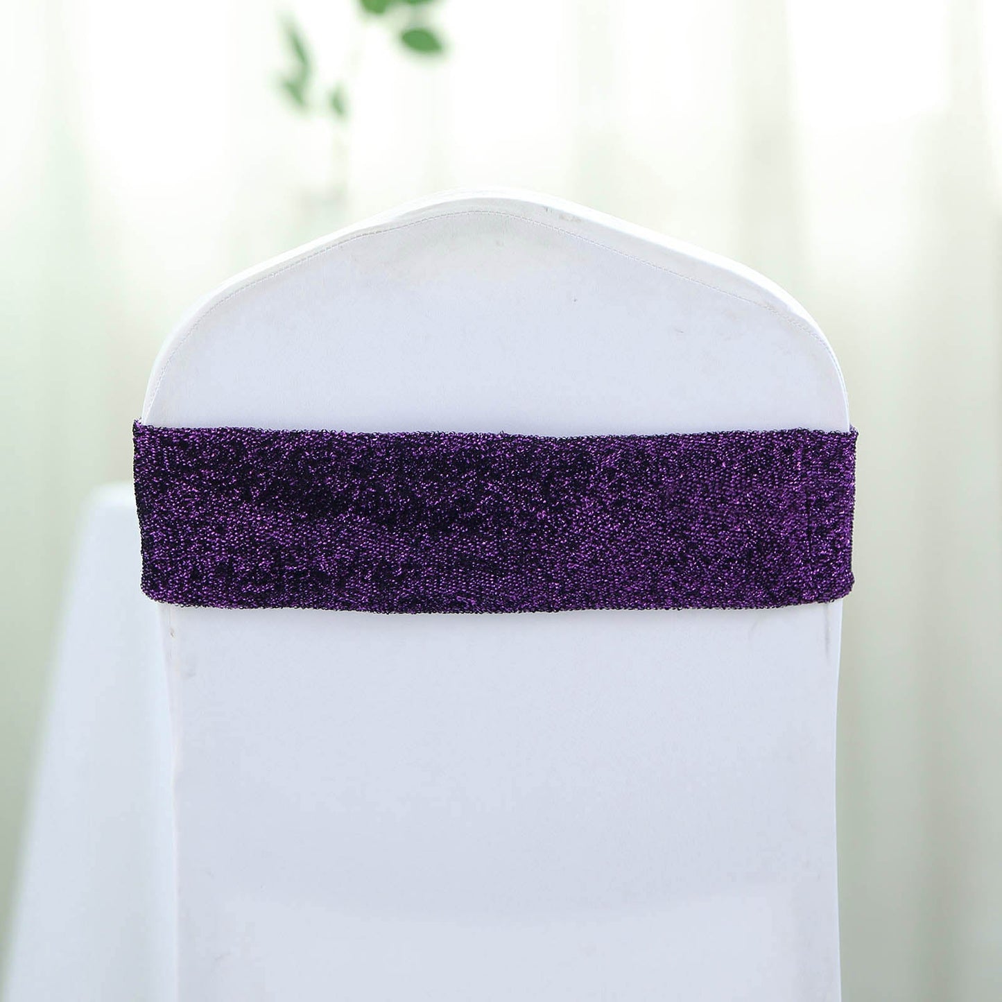 Purple metallic shimmer tinsel spandex chair sash on a white chair.