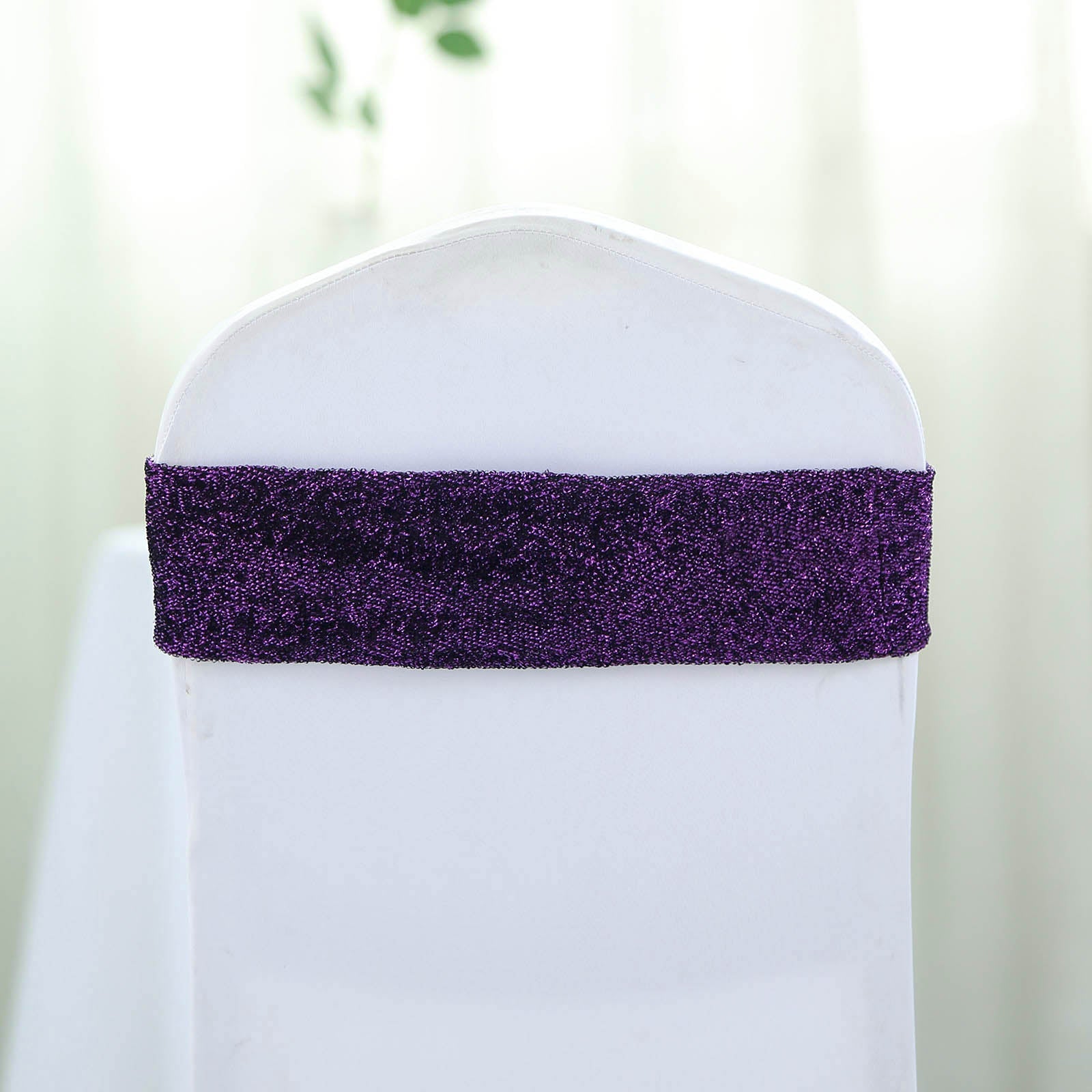 Purple metallic shimmer tinsel spandex chair sash on a white chair.