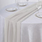 Beige chiffon table runner on a round table setting.