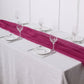 Fuchsia chiffon table runner on a white table setting.