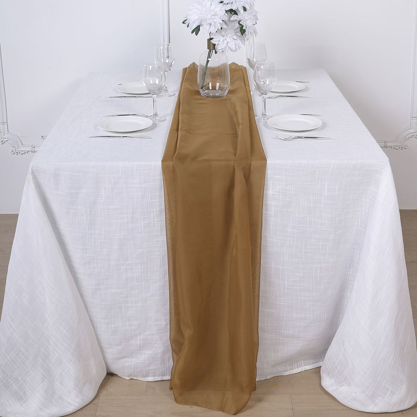 Gold chiffon table runner on a white table setting.