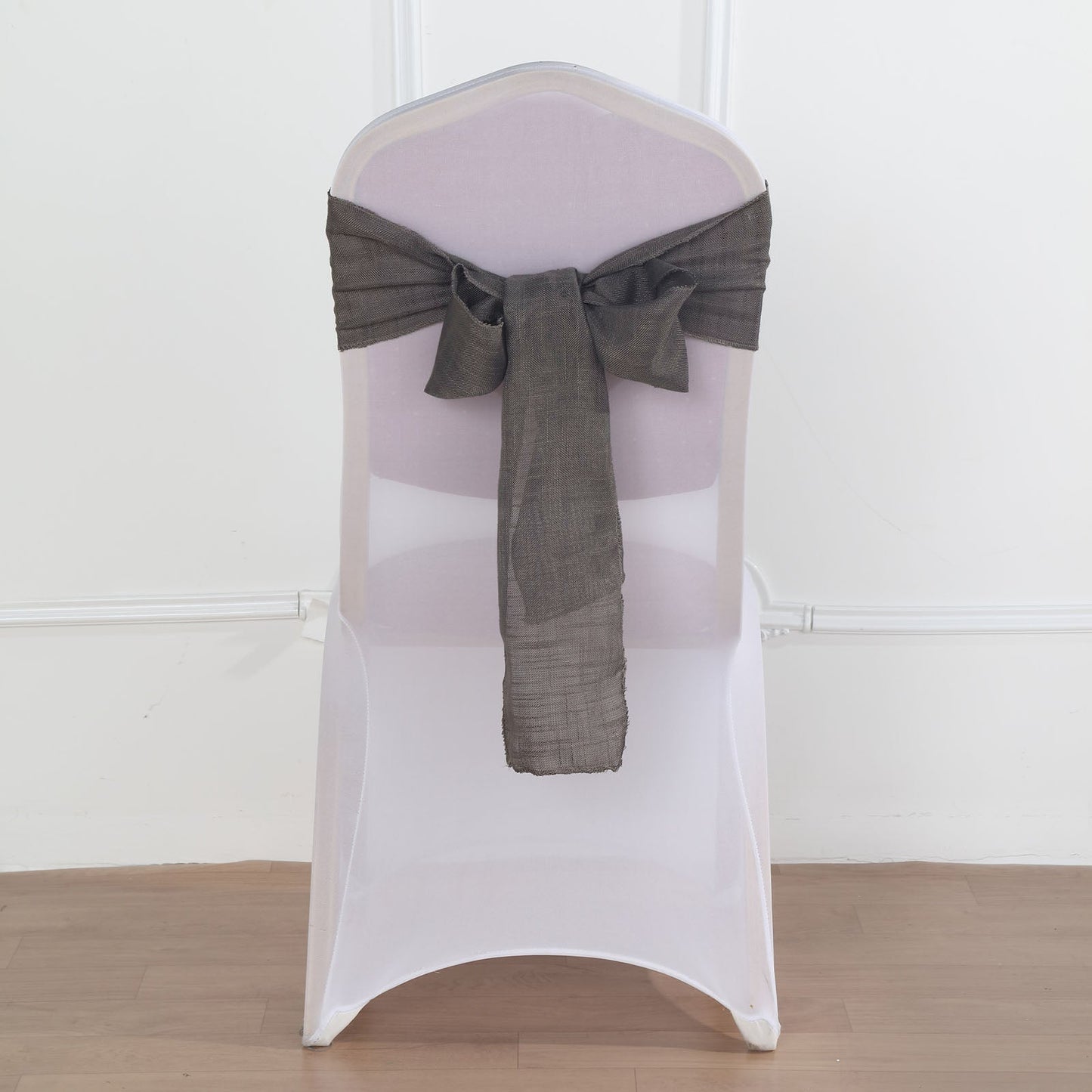 Charcoal gray linen chair sash on a white chair.