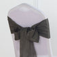 Charcoal gray linen chair sash tied in a bow on a transparent chair.