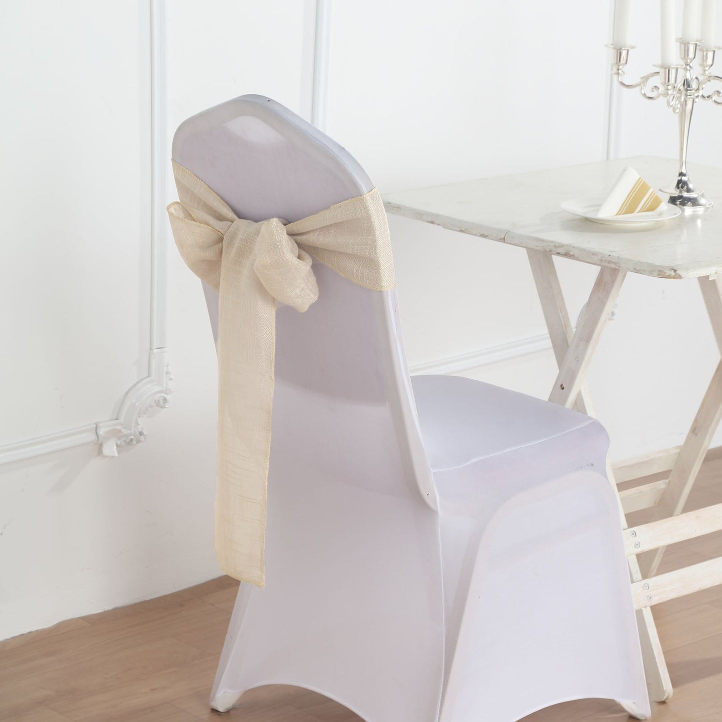 Beige linen chair sash tied on a white chair back.