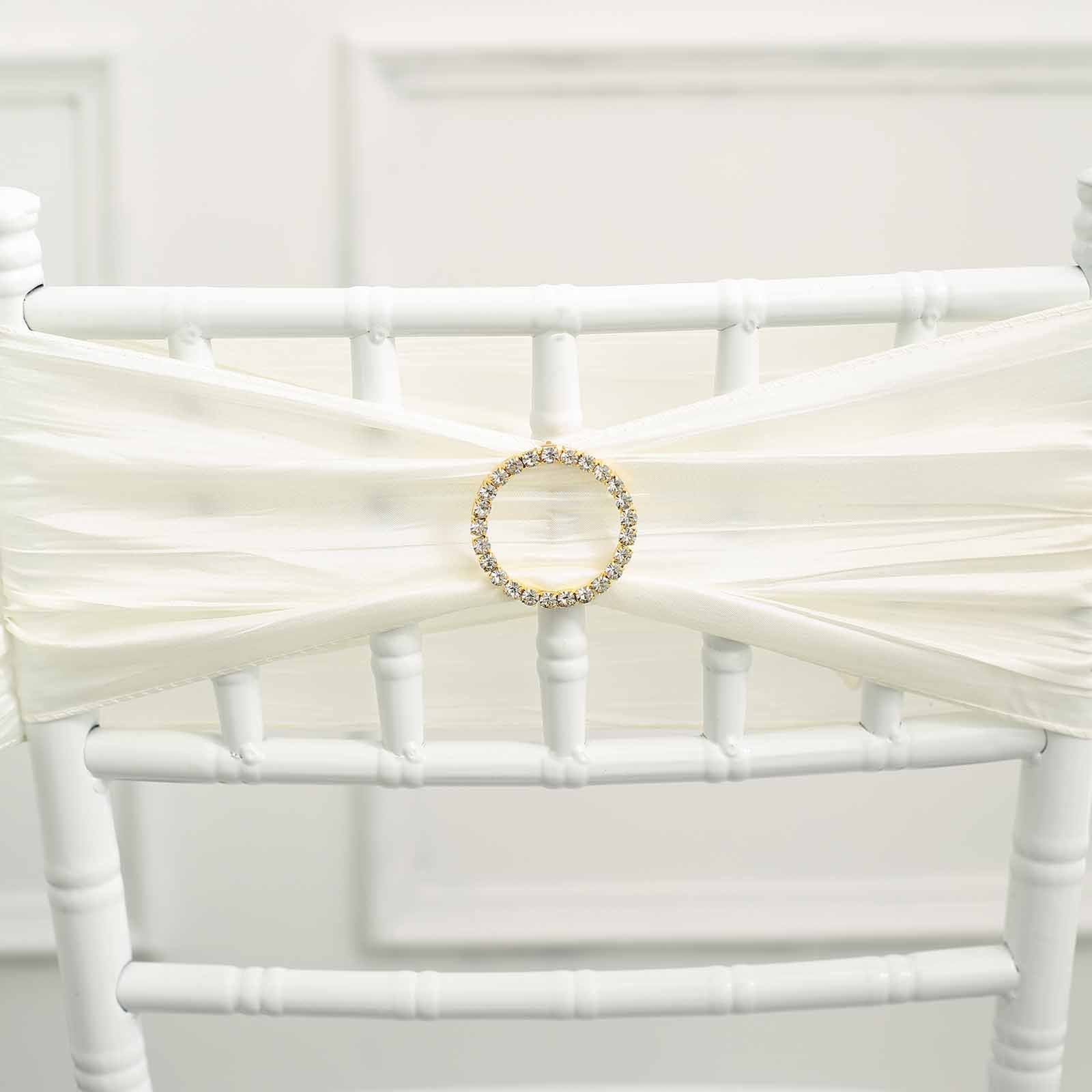 Gold rhinestone circle buckle on white chair sash.