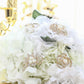 Gold plated pearl and rhinestone floral brooches on a white flower bouquet.