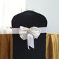 Gold plated pearl and rhinestone floral brooch on a chair sash.