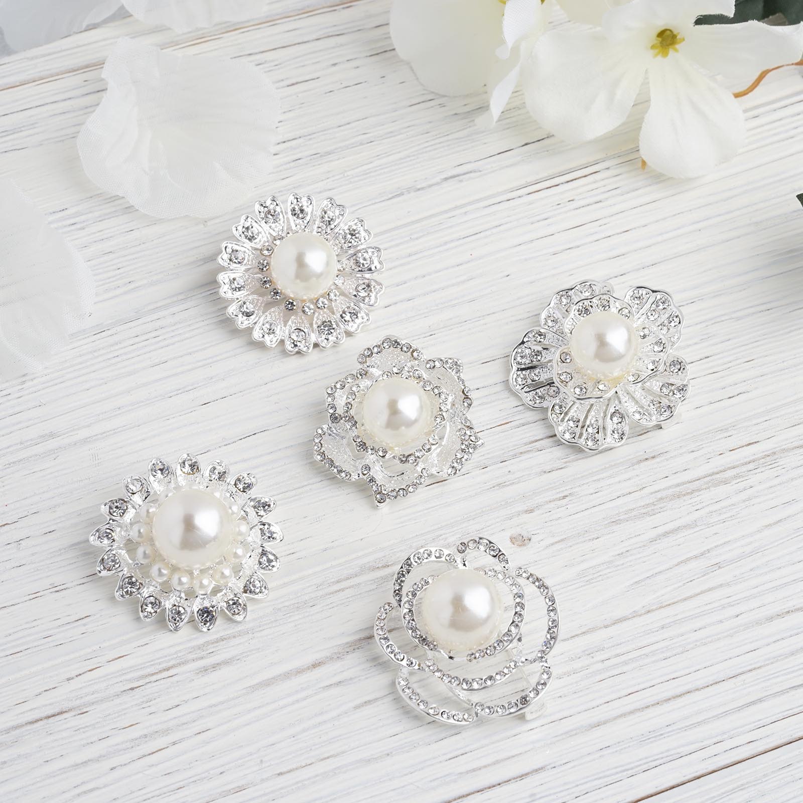 Assorted silver plated rhinestone brooches with pearl centers.