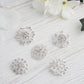 Assorted silver plated mandala crystal rhinestone brooches on a white background.