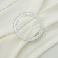 Silver diamond circle chair sash band buckle pin on cream fabric.