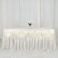 Ivory pleated satin double drape table skirt on a table with flowers.