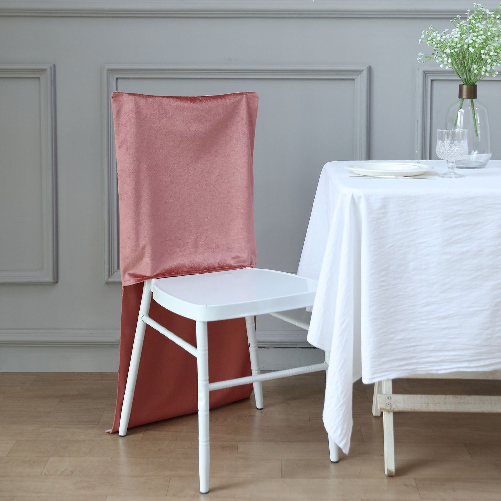 Dusty rose velvet Chiavari chair back slipcover on a white chair.