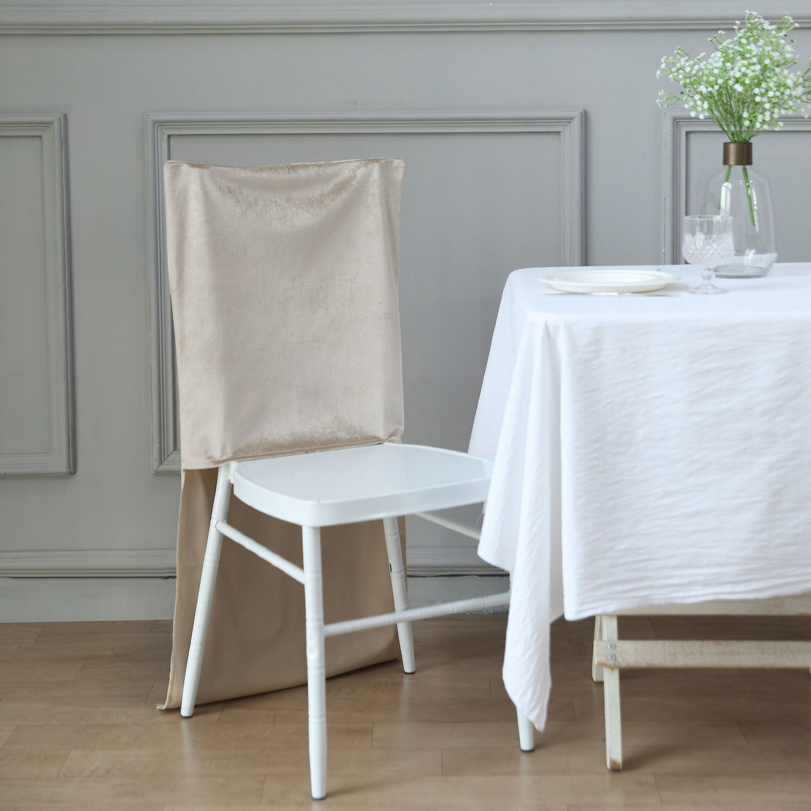 Champagne velvet Chiavari chair back slipcover on a white chair.