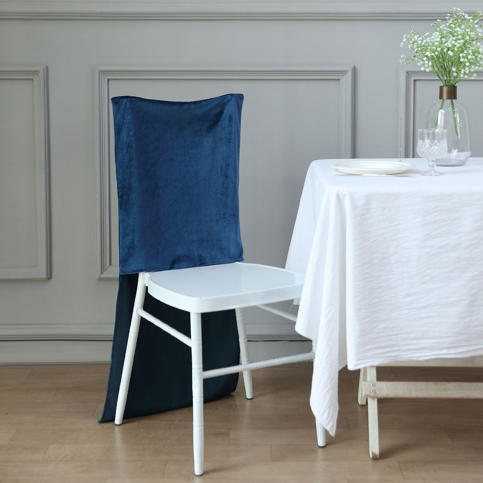 Navy blue velvet Chiavari chair back slipcover on a white chair.