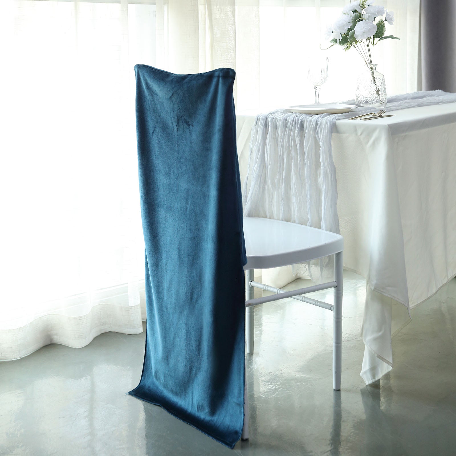 Navy blue velvet Chiavari chair back slipcover on white chair.