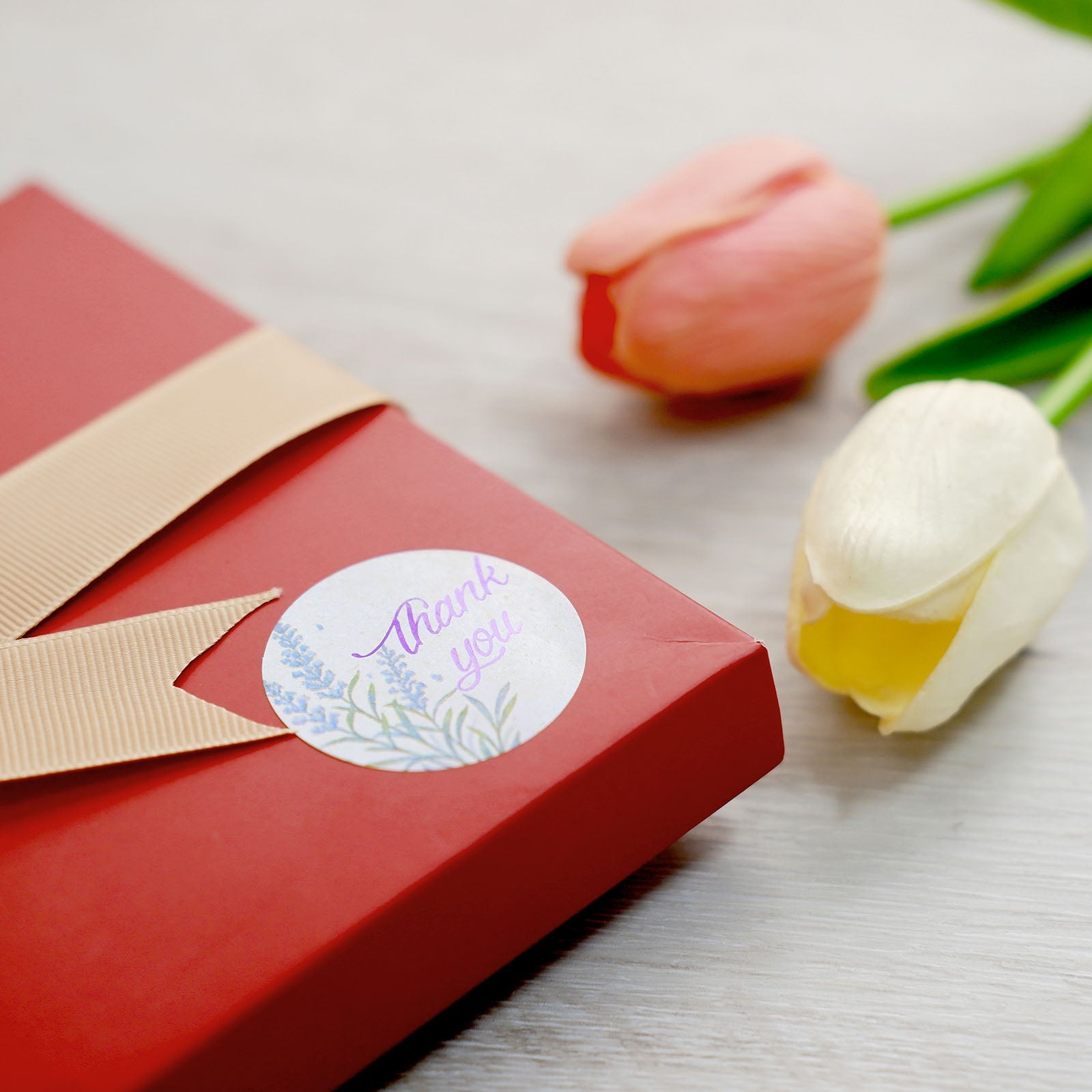 Purple lavender thank you sticker on a red gift box.