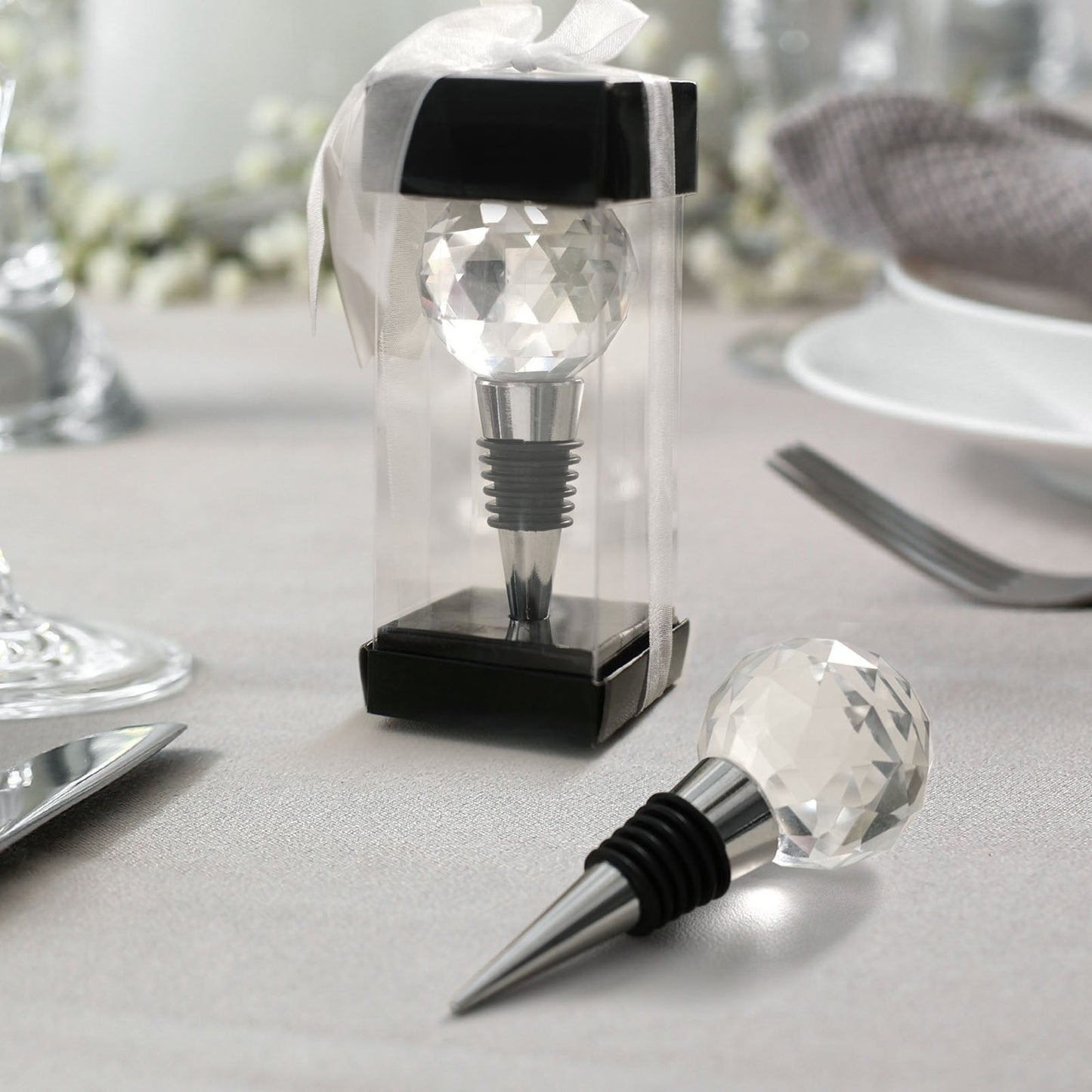 Clear crystal wine bottle stopper in a gift box with ribbon.