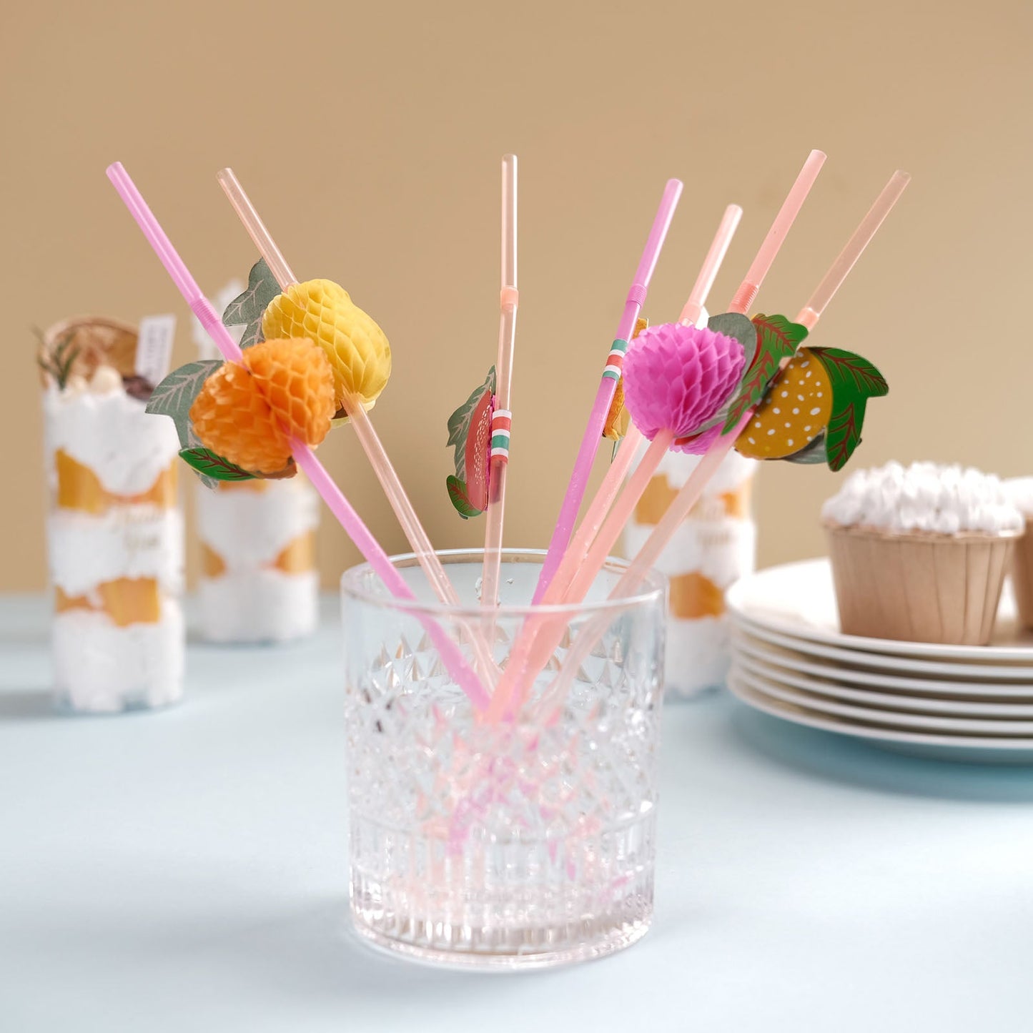 Multi-Colored tropical fruit drinking straws in a clear glass.