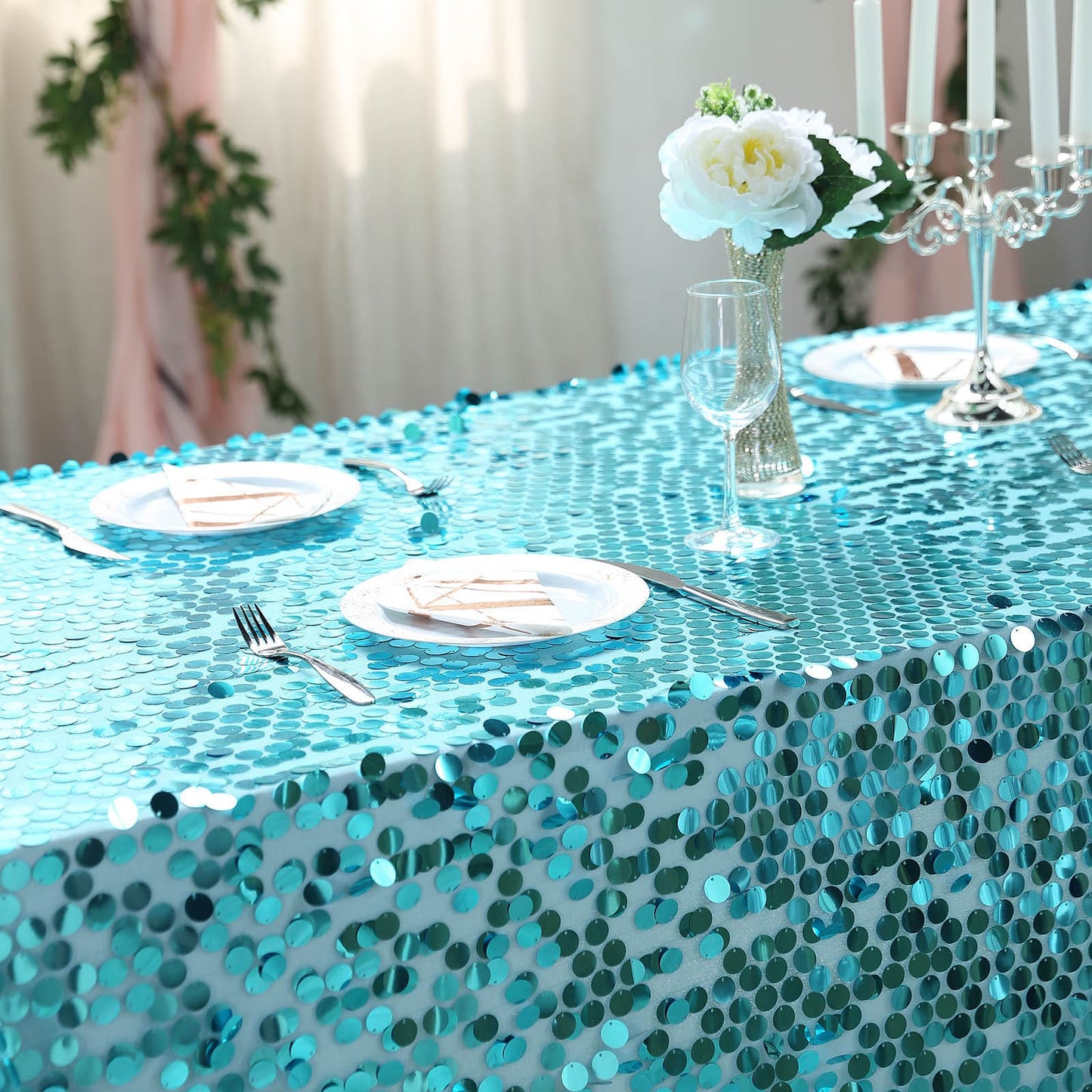 Turquoise sequin tablecloth on a decorated dining table.