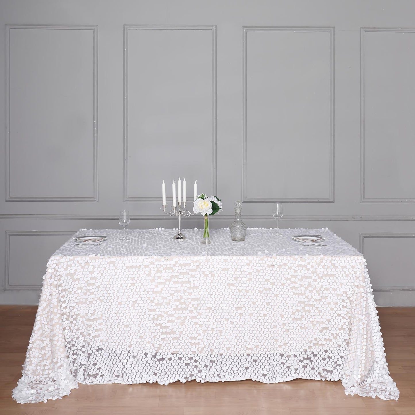 White sequin rectangle tablecloth on a styled dining table.