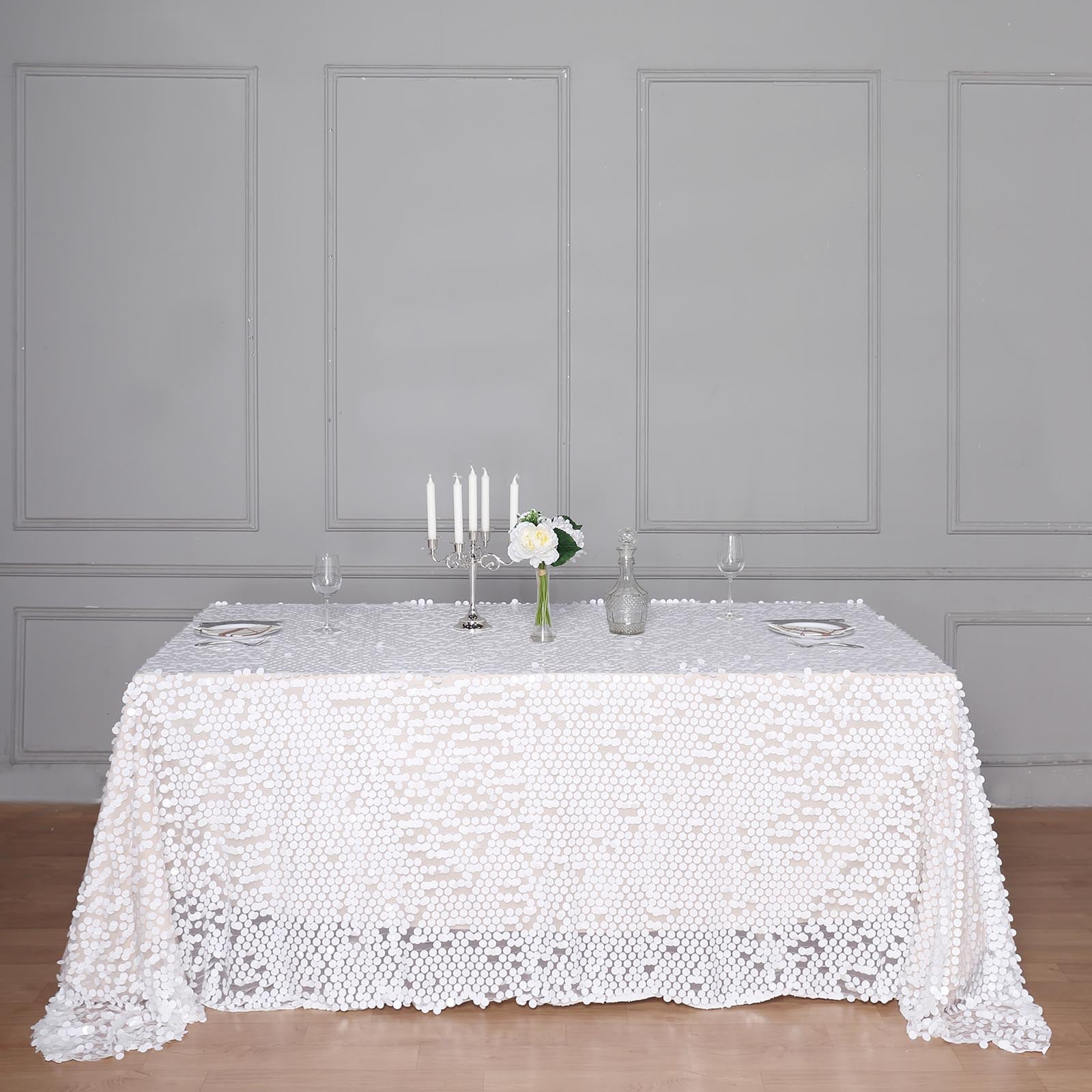 White sequin rectangle tablecloth on a styled dining table.