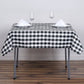 White and black buffalo plaid square table overlay on a dining table.