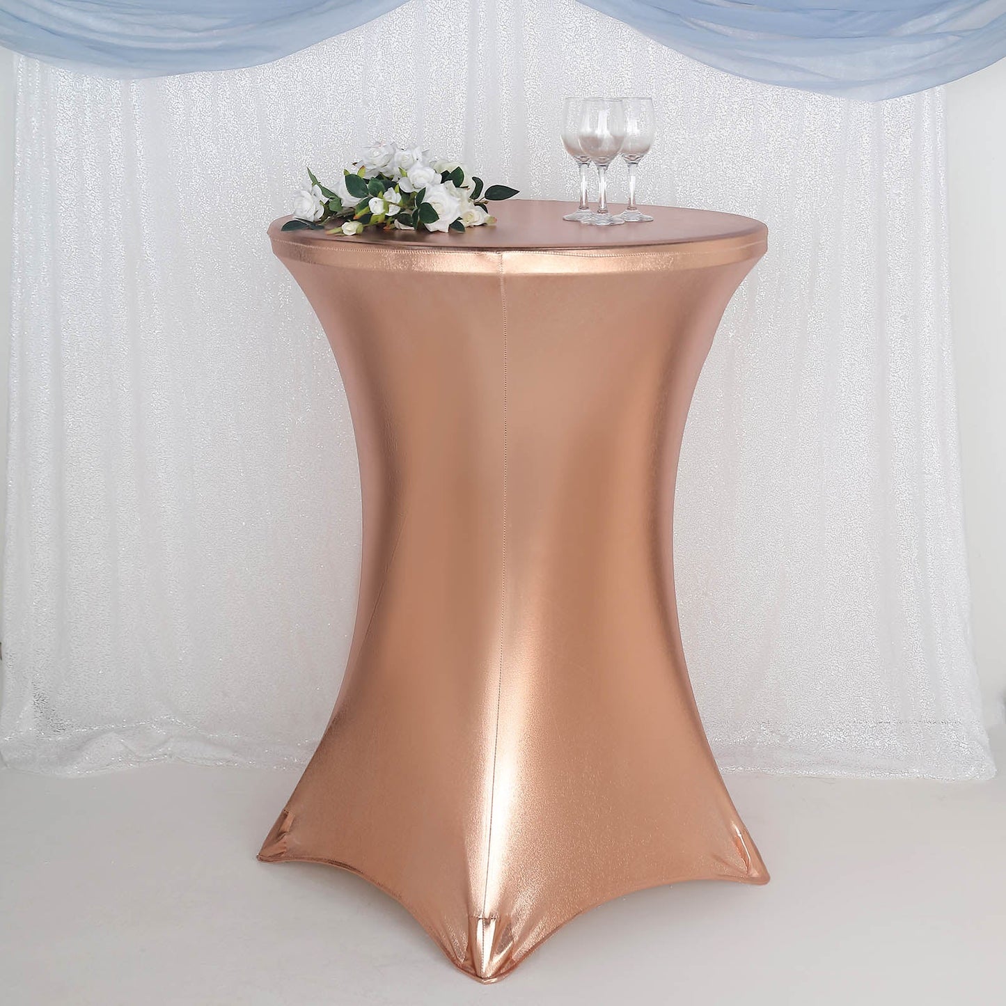 Blush metallic fitted round cocktail table cover on a highboy table.