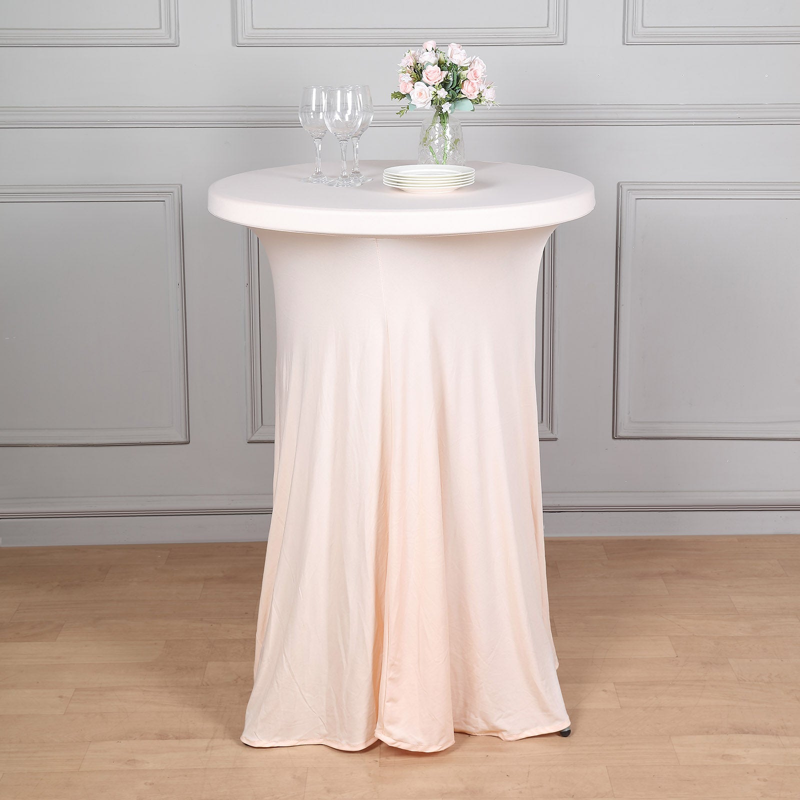Blush spandex round cocktail table cover with natural wavy drapes.