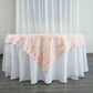 Blush square table overlay with gold foil geometric pattern.