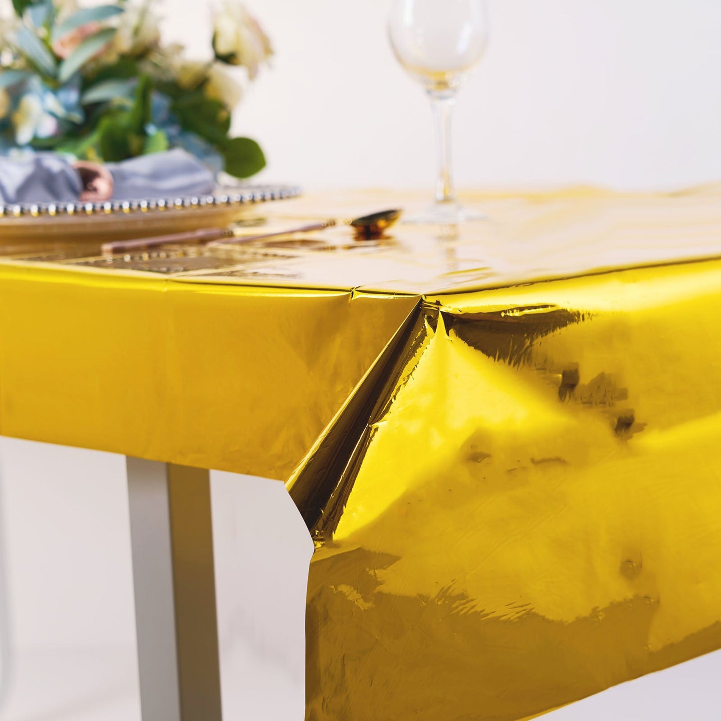 Gold metallic foil rectangle tablecloth on a table.