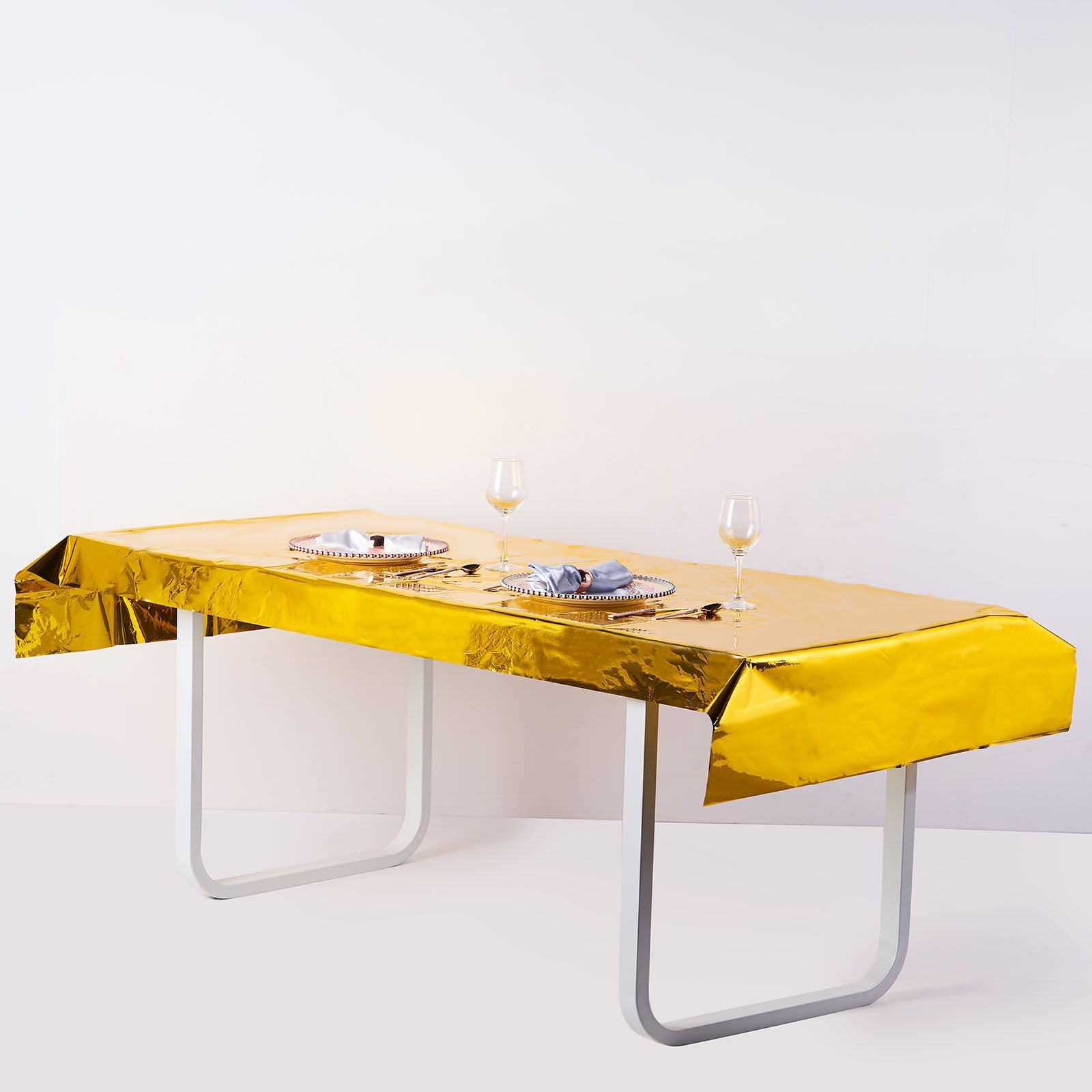 Gold metallic foil rectangle tablecloth on a table.