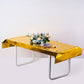 Gold metallic foil tablecloth on a table set with flowers and dinnerware.