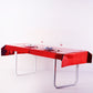 Red metallic foil disposable tablecloth on a rectangular table.